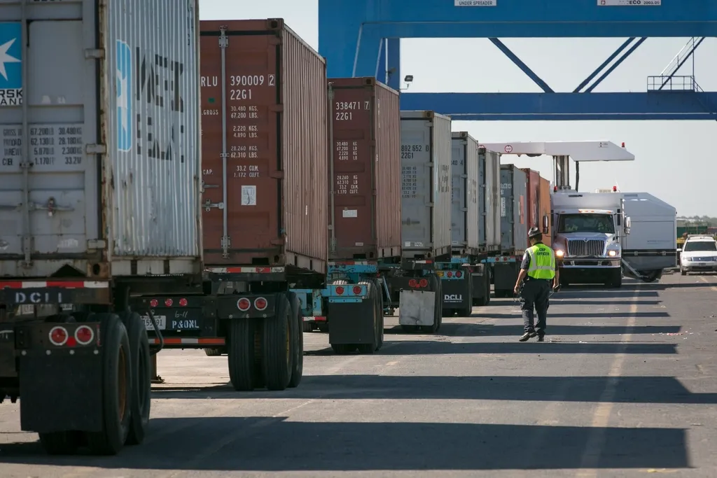 Container trucks lined up at a port terminal gate